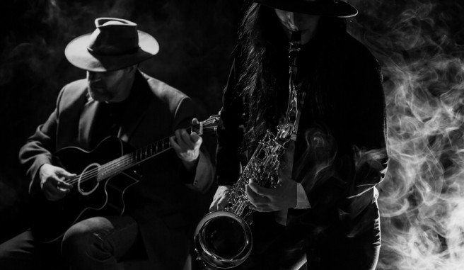 Black and white image of Sax and Guitar player in smokey room